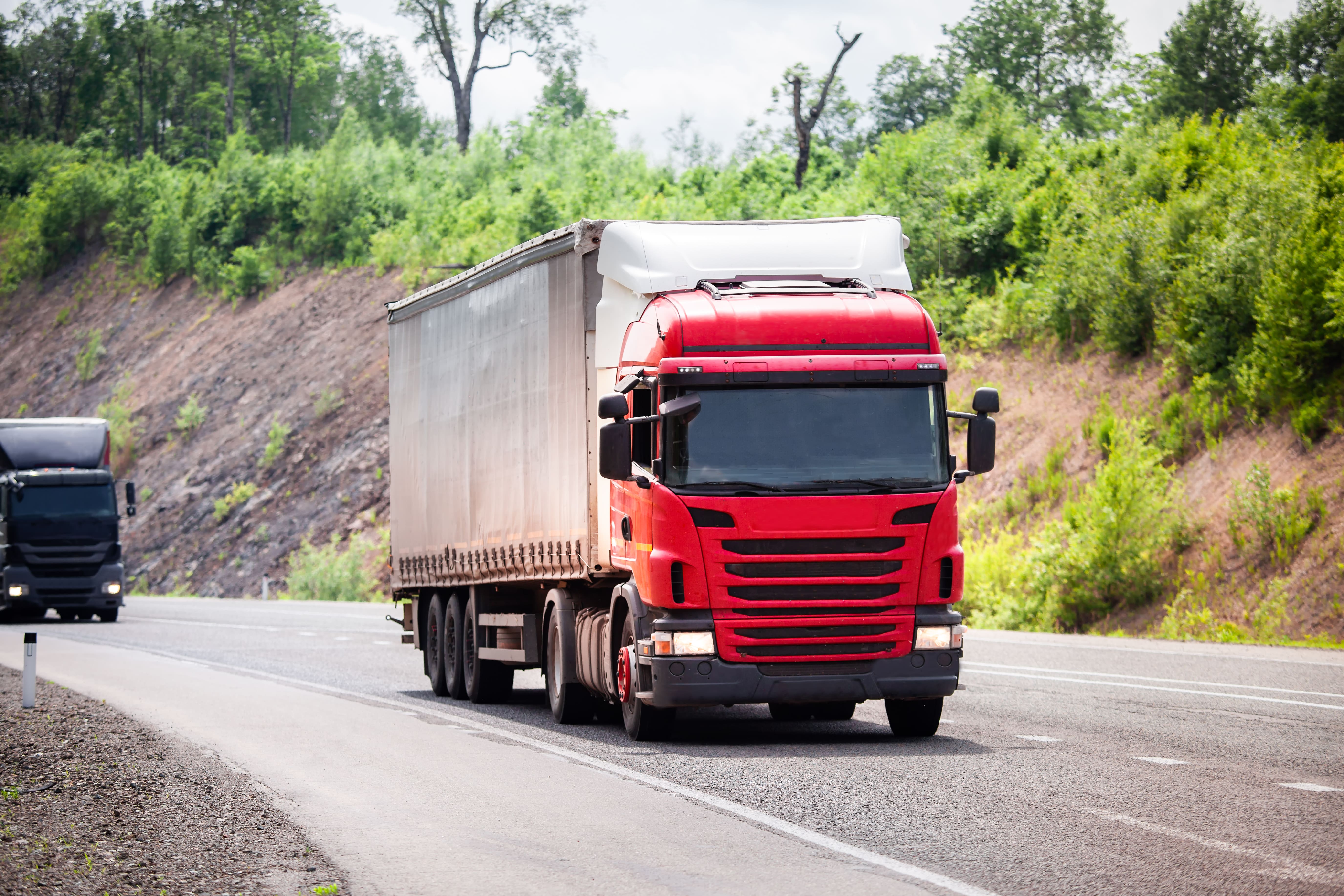 red-semi-truck-driving-highway-sunset
